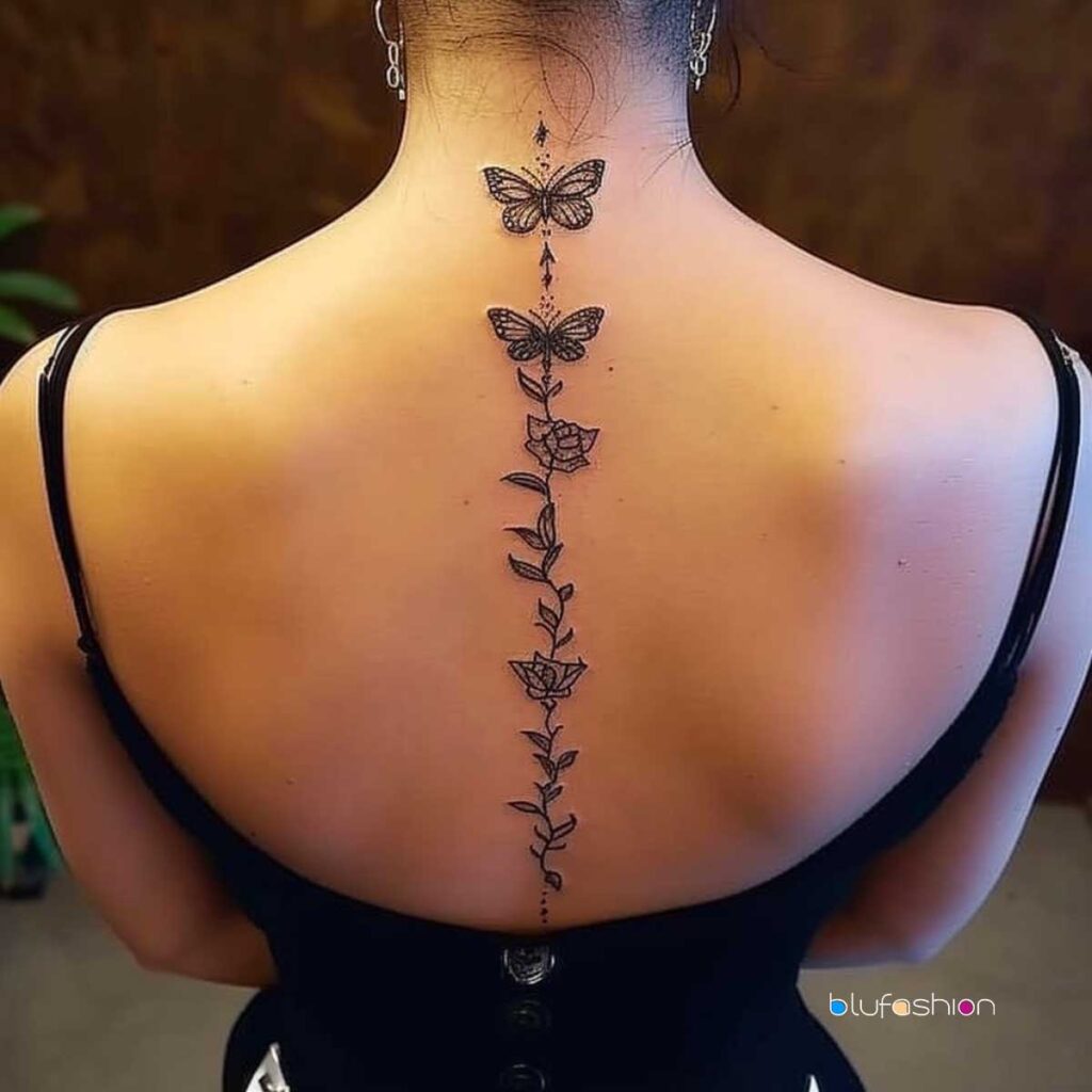 Graceful spine tattoo featuring butterflies and flowers in a delicate black ink design on a woman's back, exemplifying freedom and beauty.